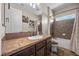 Full bathroom with tiled shower and tub and dark wood cabinets at 2577 Luberon Dr, Henderson, NV 89044