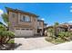 Beautiful home with a paver driveway, three-car garage, manicured lawn, and tasteful architectural details at 2577 Luberon Dr, Henderson, NV 89044
