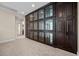 Hallway with a dark brown wall unit featuring glass display cabinets and lower storage at 2577 Luberon Dr, Henderson, NV 89044