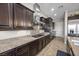 Updated kitchen boasts granite countertops, stainless steel appliances, and dark wood cabinets at 2577 Luberon Dr, Henderson, NV 89044