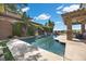 Backyard pool surrounded by lush landscaping and travertine patio at 2577 Luberon Dr, Henderson, NV 89044