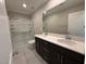 Well-lit bathroom featuring double sinks, a large mirror, and a glass-enclosed shower for modern convenience at 2620 Tolmezzo St, Henderson, NV 89044