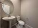Half bathroom featuring a pedestal sink, round mirror, and tiled floor at 2620 Tolmezzo St, Henderson, NV 89044