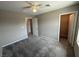 A well-lit bedroom with neutral walls, carpeting, and a ceiling fan, adjoining walk-in closet at 2620 Tolmezzo St, Henderson, NV 89044