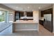 Modern kitchen boasts an island, stainless steel appliances, and sliding door access to the backyard at 2620 Tolmezzo St, Henderson, NV 89044