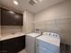 Functional laundry room with a utility sink, storage cabinets, and washer/dryer hookups for convenience at 2620 Tolmezzo St, Henderson, NV 89044