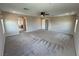 Spacious carpeted main bedroom boasts an ensuite bathroom, fan, and access to a hallway at 2620 Tolmezzo St, Henderson, NV 89044