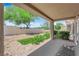 Covered back patio with seating overlooks a low-maintenance landscaped yard and mature trees at 2701 Glencliff Dr, Las Vegas, NV 89134