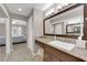 Bathroom featuring a granite countertop, brown cabinets, and a large mirror with vanity lighting at 2701 Glencliff Dr, Las Vegas, NV 89134