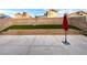 Well-kept backyard featuring a concrete patio, stone retaining wall, synthetic grass, and block fence at 2813 Painted Rose Ln, Henderson, NV 89074
