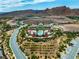 Aerial view highlighting the community pool, clubhouse, with lush landscaping and surrounding desert terrain at 30 Via Vasari # 103, Henderson, NV 89011