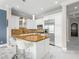 Bright kitchen features white cabinetry, stainless steel appliances, a granite island, and sleek marble floors at 30 Via Vasari # 103, Henderson, NV 89011