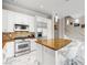 Modern kitchen boasts white cabinets, stainless steel appliances, a granite island, and marble floors at 30 Via Vasari # 103, Henderson, NV 89011