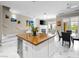 Open-concept kitchen with a large island featuring granite countertops, marble floors, and modern pendant lighting at 30 Via Vasari # 103, Henderson, NV 89011