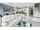 Bright, open-concept living room showcasing a sleek kitchen with white cabinetry and stainless steel appliances at 30 Via Vasari # 103, Henderson, NV 89011