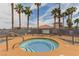 Community spa area with tiled pool, lounge chairs, and palm trees in the background at 3318 N Decatur Blvd # 1020, Las Vegas, NV 89130