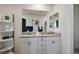 Bathroom featuring double sinks, white cabinets, and a large mirror at 3531 Montepulciano Ln, Henderson, NV 89044