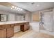 Bright bathroom features dual sinks, large mirror, soaking tub, and separate glass shower at 405 Prairie Moon Ave, North Las Vegas, NV 89084