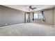 This spacious bedroom boasts plush carpets, a ceiling fan, and two windows for ample natural light at 405 Prairie Moon Ave, North Las Vegas, NV 89084