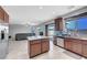 Open kitchen and living area with granite countertops, stainless steel appliances, a kitchen island, and tile flooring at 405 Prairie Moon Ave, North Las Vegas, NV 89084