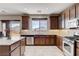 Modern kitchen with wood cabinets, a kitchen island, granite countertops, and stainless appliances at 405 Prairie Moon Ave, North Las Vegas, NV 89084