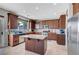 Kitchen featuring granite countertops, stainless steel appliances, a center island, tile flooring and wood cabinets at 405 Prairie Moon Ave, North Las Vegas, NV 89084