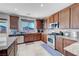 Kitchen featuring stainless steel appliances, granite countertops, tiled floors, and wood cabinetry at 405 Prairie Moon Ave, North Las Vegas, NV 89084