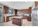 Bright kitchen featuring dark wood cabinets, stainless steel appliances, a center island, and tile floors at 405 Prairie Moon Ave, North Las Vegas, NV 89084