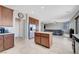 Open kitchen with stainless steel refrigerator, center island, and seamless flow into the living area at 405 Prairie Moon Ave, North Las Vegas, NV 89084