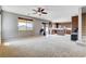 Inviting living room with plush carpeting, ceiling fan, and an open floor plan to a modern kitchen with island at 405 Prairie Moon Ave, North Las Vegas, NV 89084
