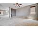 Bright living room featuring plush carpet, neutral paint, a ceiling fan, and a view of the entryway at 405 Prairie Moon Ave, North Las Vegas, NV 89084