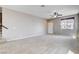 Large living room featuring a staircase, neutral carpet and a ceiling fan at 405 Prairie Moon Ave, North Las Vegas, NV 89084