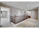 Second floor landing with wood railing, and doorway to bedrooms with carpeting and recessed lighting at 405 Prairie Moon Ave, North Las Vegas, NV 89084