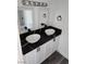 Bathroom featuring a double vanity with black marble countertops and vessel sinks at 4231 E Kellogg Rd, Pahrump, NV 89061
