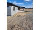 Exterior view of a home featuring gray siding, a covered porch, and a gravel yard at 4231 E Kellogg Rd, Pahrump, NV 89061