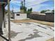 View of the backyard with shed, partial concrete pad and wood privacy fence at 4525 Fulton Pl, Las Vegas, NV 89107