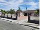 Charming single-story home with light brown siding, solar panels, gated yard and rock landscaping at 4525 Fulton Pl, Las Vegas, NV 89107