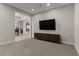 View of the living room featuring neutral carpet, modern cabinet, and a large TV at 47 Garibaldi Way, Henderson, NV 89011