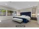 Staged primary bedroom with a luxurious bed, modern chandelier, and neutral color scheme at 47 Garibaldi Way, Henderson, NV 89011