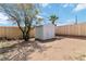 View of the backyard with storage shed, wood fence, and sparse landscaping on a sunny day at 49 Constitution Ave, Henderson, NV 89015