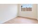 Bright, empty bedroom features light wood floors, white walls, and a window with a view at 49 Constitution Ave, Henderson, NV 89015