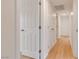 Hallway featuring wood-look floors, white walls, and doors leading to various rooms at 49 Constitution Ave, Henderson, NV 89015