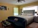 Cozy bedroom featuring a plush bed, a soft blue couch, and warm yellow walls for a relaxing ambiance at 5043 Gable Crest Ct, Las Vegas, NV 89141