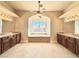 Elegant bathroom with dual vanities, a soaking tub under a window, and tile flooring at 5451 Fernwood Ct, Pahrump, NV 89061