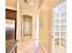 Hallway with tile flooring, and a view of the pantry and stainless steel refrigerator at 5451 Fernwood Ct, Pahrump, NV 89061