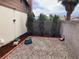 Backyard gravel area enhanced by three tall evergreen trees at 5821 Santa Catalina Ave, Las Vegas, NV 89108
