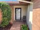 Inviting front entrance with a decorative glass door, accent chair, and mature landscaping at 5821 Santa Catalina Ave, Las Vegas, NV 89108
