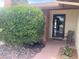 Cozy covered front porch with a chair, brick accents, decorative rocks, and a black front door at 5821 Santa Catalina Ave, Las Vegas, NV 89108
