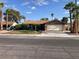 Charming single-story home featuring a lush front lawn, palm trees, and a two-car garage at 5821 Santa Catalina Ave, Las Vegas, NV 89108