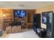 Living room featuring built-in bookshelves, a brick fireplace, and a large television for entertainment at 5821 Santa Catalina Ave, Las Vegas, NV 89108